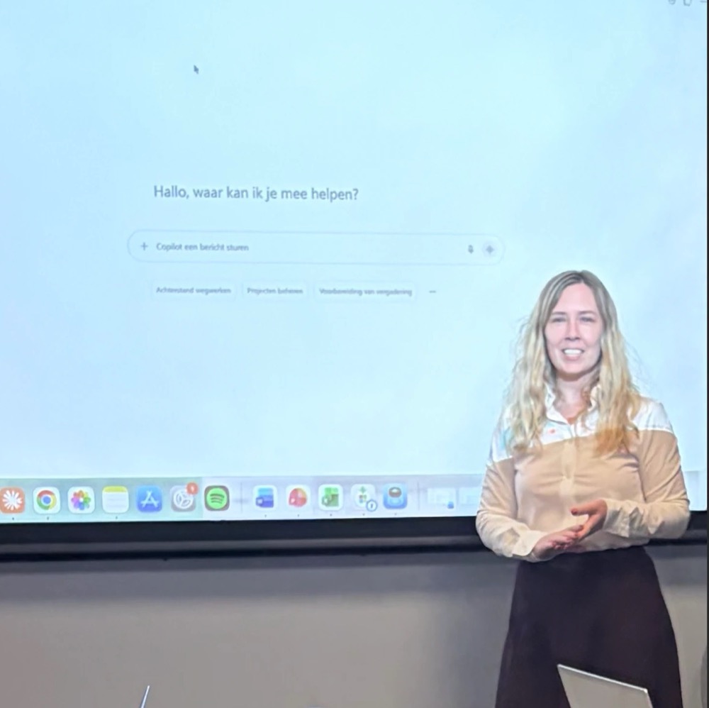 Esra van Beelen geeft een Copilot-training, met Copilot op het scherm achter haar